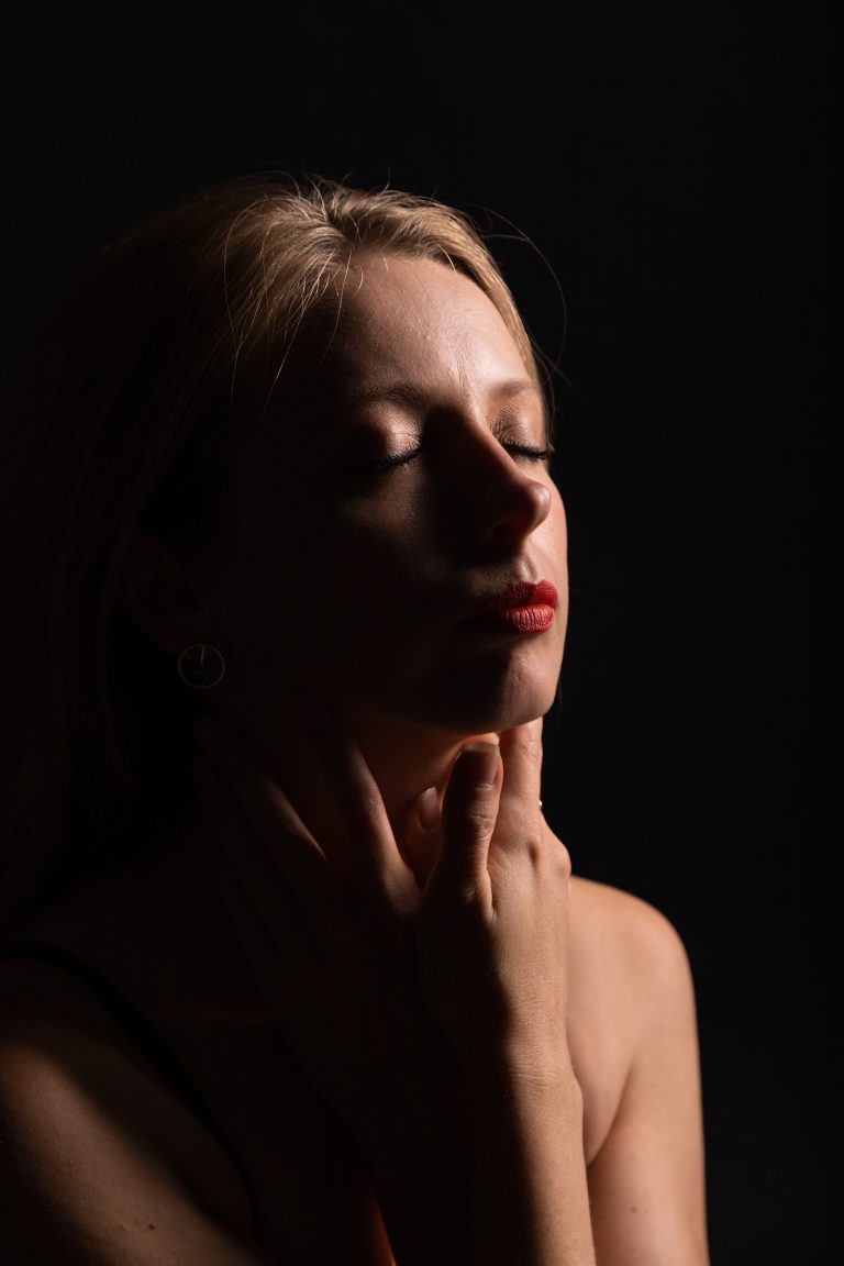 Ein leises, emotionales Low-Key-Porträt, das die innere Ruhe, Sensibilität und Tiefe der Frau in einem Moment geschlossener Augen einfängt.